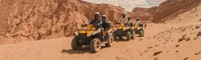 Quad bike group riding through a rocky desert canyon