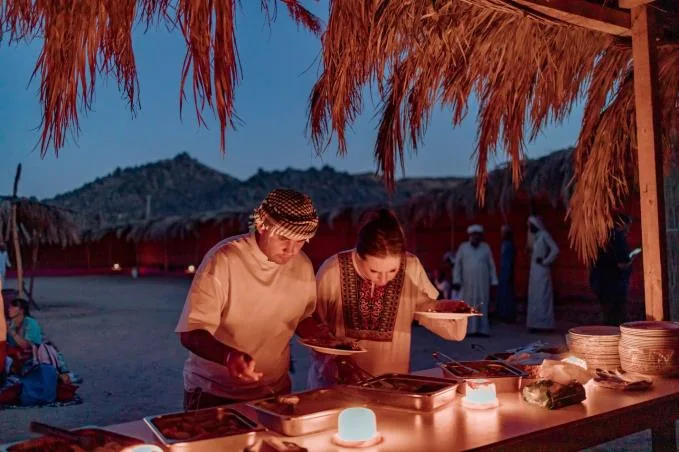 Guests selecting dinner at a candle-lit desert buffet