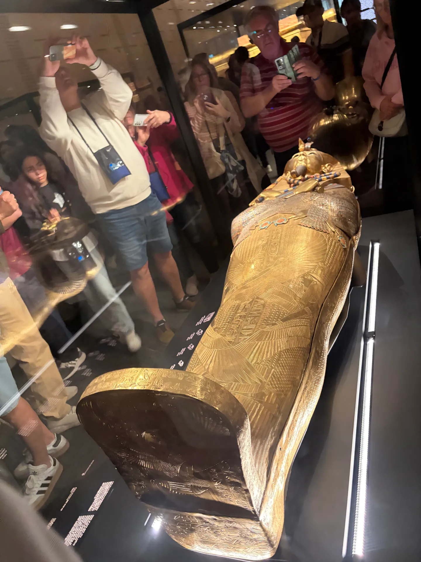 Ancient pharaoh sculpture displayed behind protective glass
