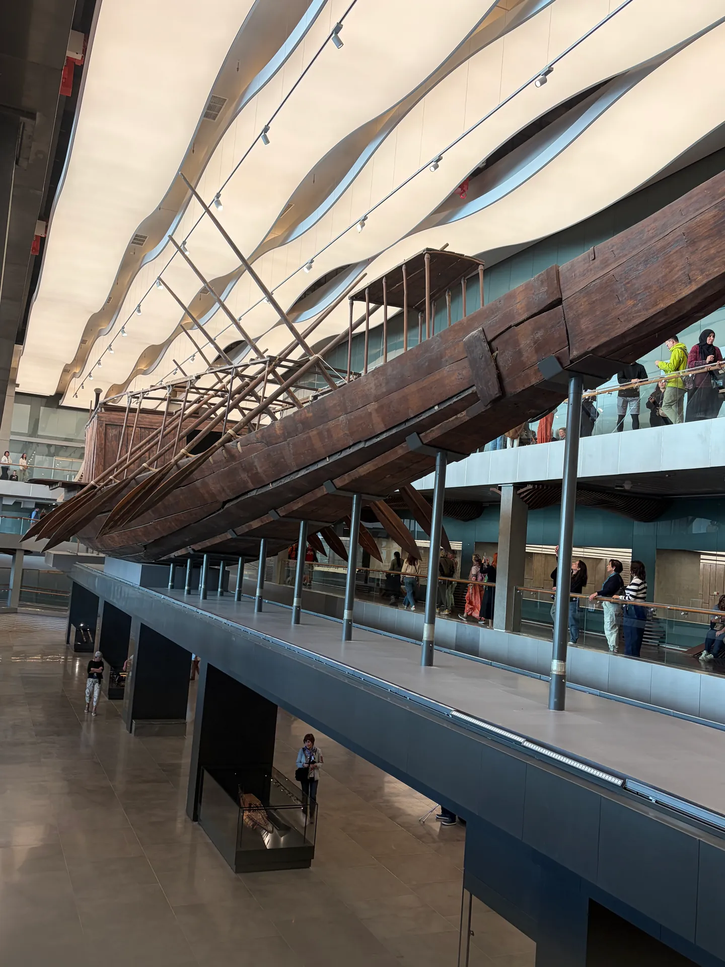 Ancient boat displayed above the Grand Egyptian Museum atrium