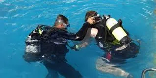 Instructor assisting a first-time diver at the surface
