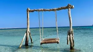 Wooden sea swing in the shallow water at Eden Island