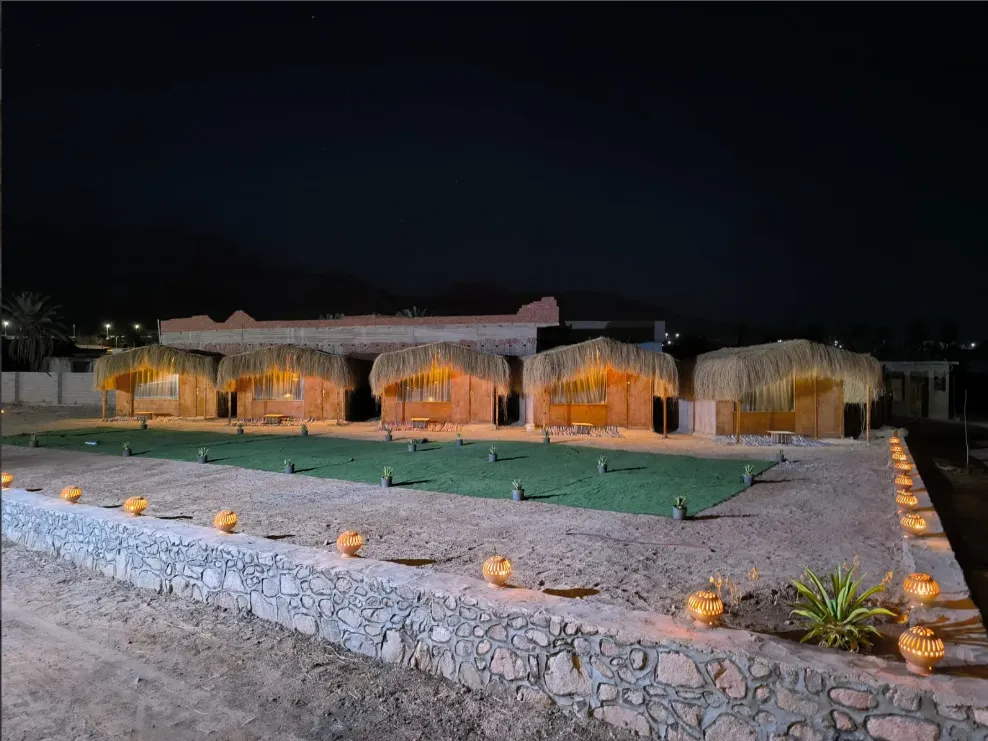 Beach camp huts lit by candles at night