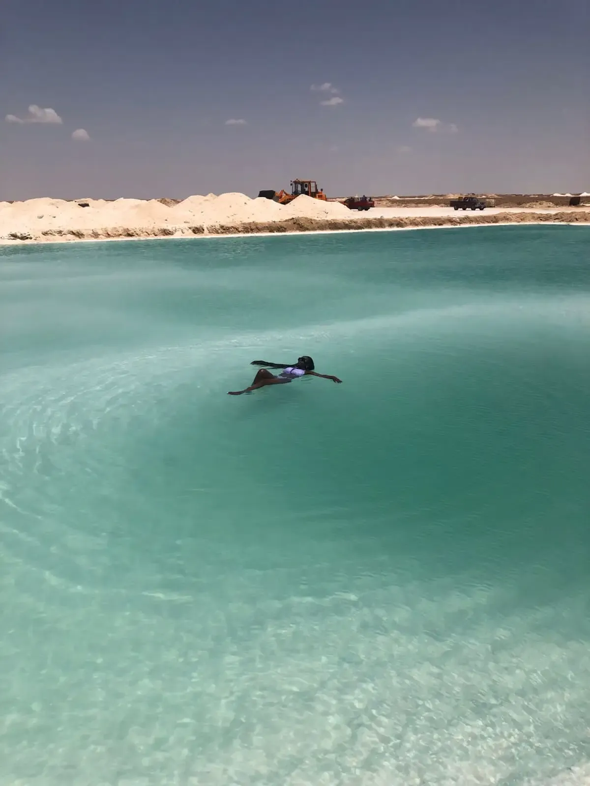 Swimmer floating in a bright blue Siwa salt pool
