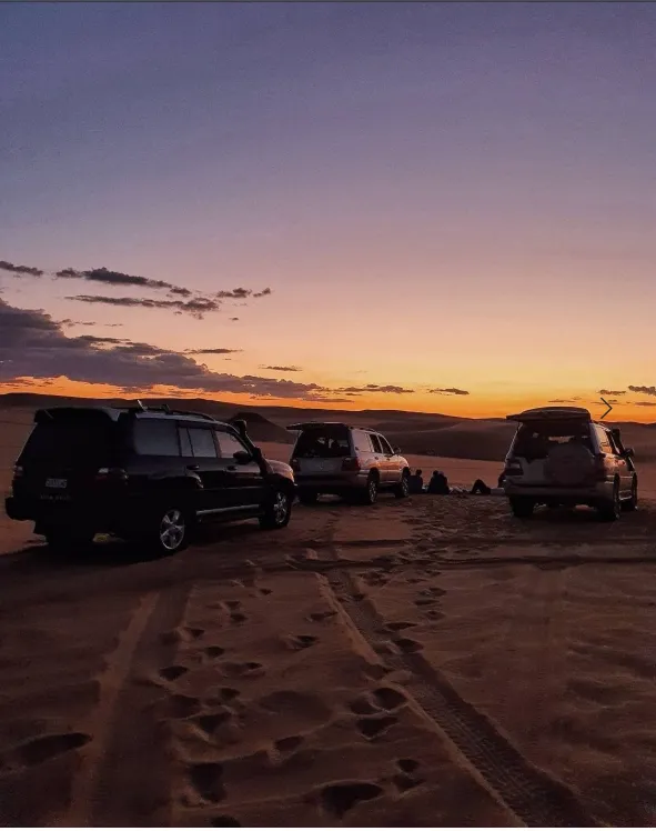 Sunset over safari vehicles in the Great Sand Sea