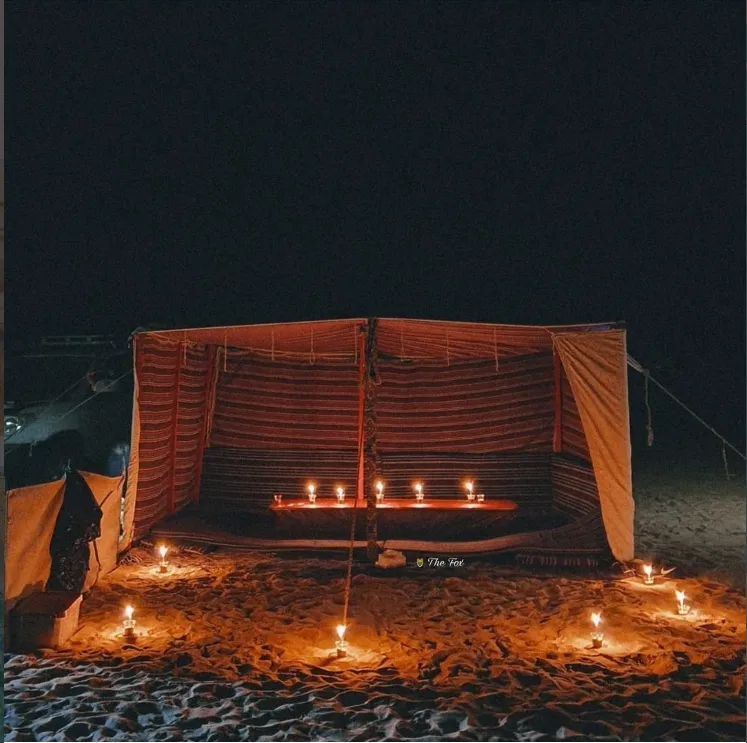 Candlelit desert camp beneath the night sky in Siwa