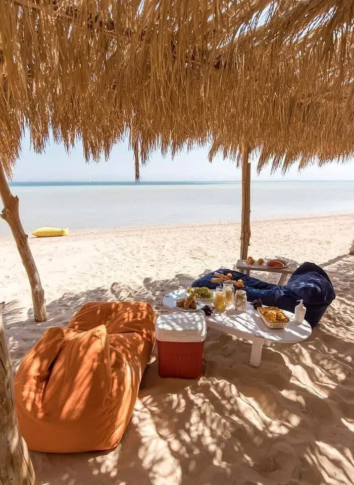 Beach shade with breakfast setup on the white sand at Orange Bay